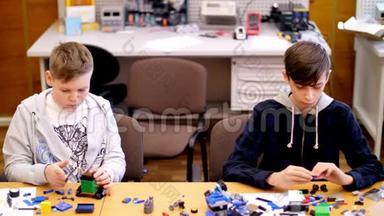 <strong>十二岁</strong>的男孩，从立方体、盘子、电路、电线中扮演设计师。 小发明家创造机器人，机器来自